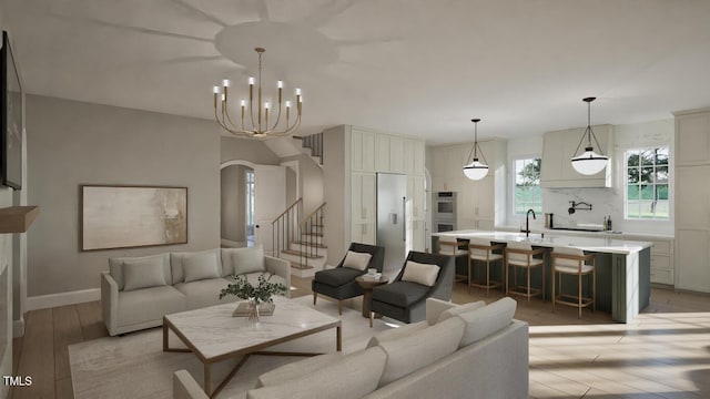 913 Tyrrell Rd, Raleigh, NC 27609 - living room with light wood finished floors, stairway, a chandelier, and baseboards
