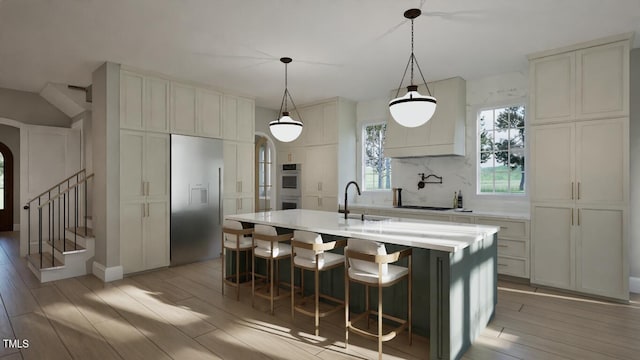 913 Tyrrell Rd, Raleigh, NC 27609 - kitchen with built in refrigerator, a sink, arched walkways, and light wood-style floors