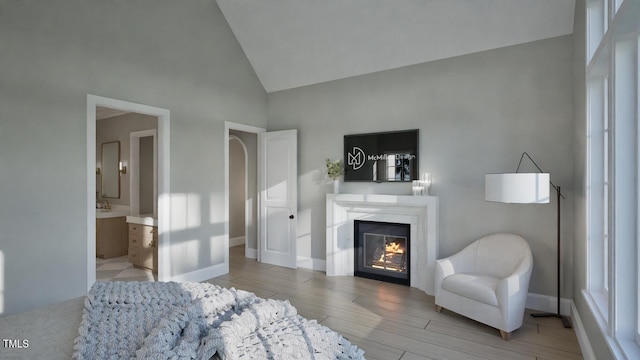913 Tyrrell Rd, Raleigh, NC 27609 - bedroom featuring wood finished floors, a glass covered fireplace, high vaulted ceiling, ensuite bath, and baseboards