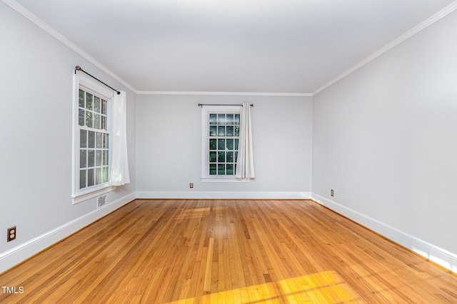 spare room with light wood-style flooring, ornamental molding, and baseboards