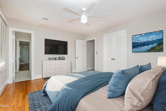 bedroom featuring baseboards, light wood finished floors, a closet, and ceiling fan