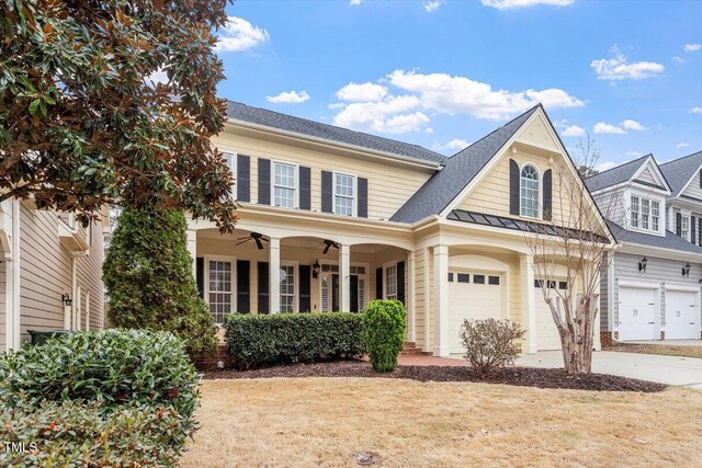 view of front of home featuring driveway, ceiling fan, a garage, a shingled roof, and a standing seam roof