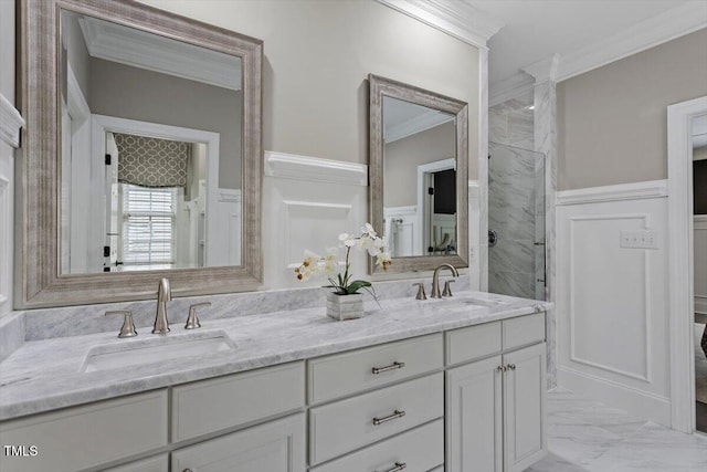 full bathroom with ornamental molding, marble finish floors, wainscoting, tiled shower, and double vanity