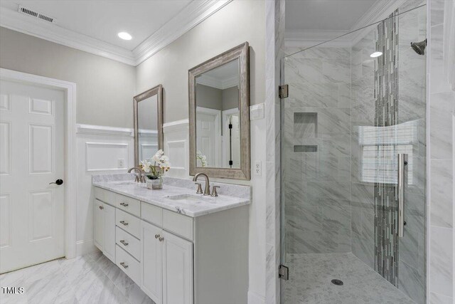 bathroom with crown molding, a stall shower, double vanity, marble finish flooring, and a wainscoted wall