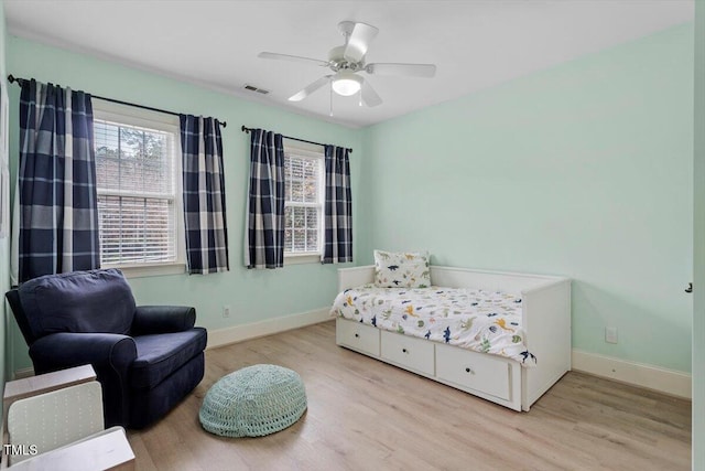 bedroom featuring multiple windows, wood finished floors, and baseboards