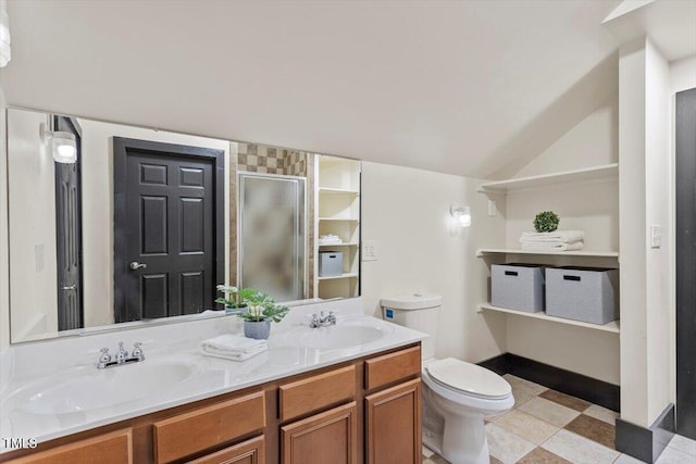 bathroom featuring a shower stall, double vanity, toilet, and vaulted ceiling
