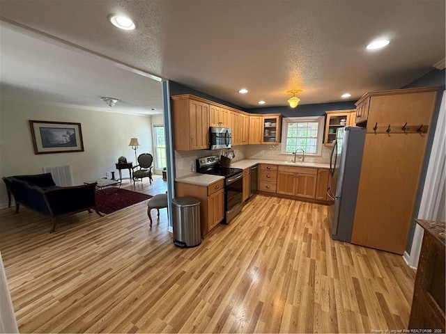 73 Night Heron Ct, Sanford, NC 27332 - kitchen with stainless steel appliances, a sink, light wood-style flooring, light countertops, and recessed lighting