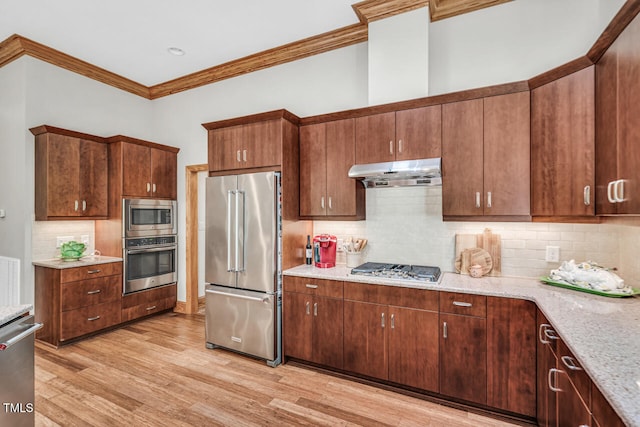 289 Stoneview, Pittsboro, NC 27312 - kitchen featuring stainless steel appliances, under cabinet range hood, ornamental molding, light wood-style flooring, and backsplash