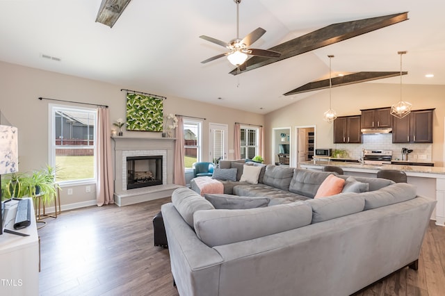 living area featuring wood finished floors, a brick fireplace, and ceiling fan