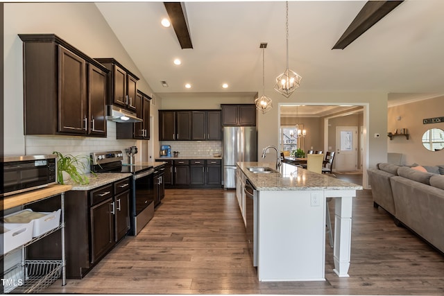 kitchen featuring appliances with stainless steel finishes, under cabinet range hood, a sink, a chandelier, and open floor plan