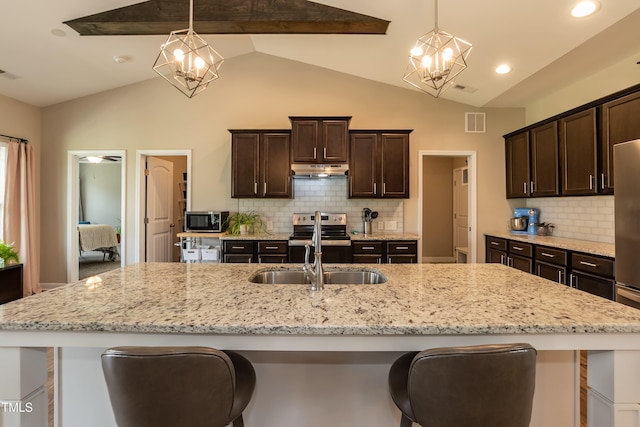 kitchen with stainless steel appliances, a chandelier, a sink, vaulted ceiling, and dark brown cabinetry