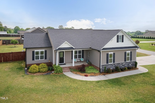 traditional-style house with roof with shingles, covered porch, and stone siding