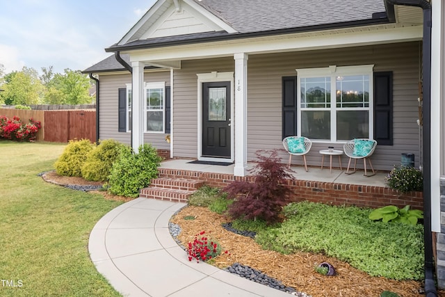 doorway to property featuring roof with shingles and a porch
