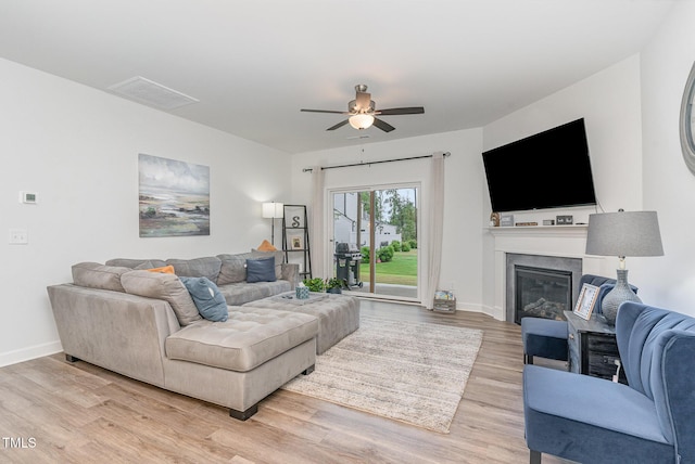 646 Shelford Trl, Zebulon, NC 27597 - living room with a ceiling fan, light wood-type flooring, a glass covered fireplace, and baseboards
