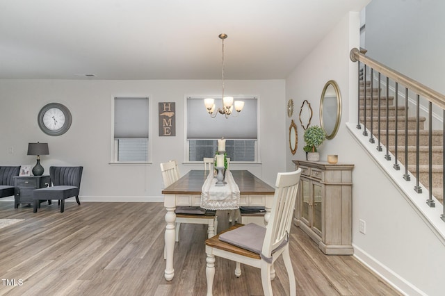 646 Shelford Trl, Zebulon, NC 27597 - dining area with light wood finished floors, a chandelier, and baseboards