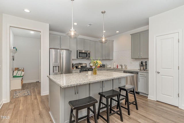 646 Shelford Trl, Zebulon, NC 27597 - kitchen featuring stainless steel appliances, gray cabinets, a sink, a center island, and recessed lighting