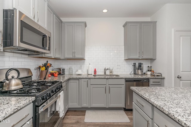 646 Shelford Trl, Zebulon, NC 27597 - kitchen featuring appliances with stainless steel finishes, a sink, gray cabinetry, dark wood-style floors, and recessed lighting