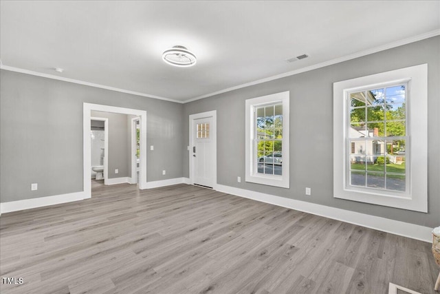 unfurnished room with wood finished floors, crown molding, and baseboards