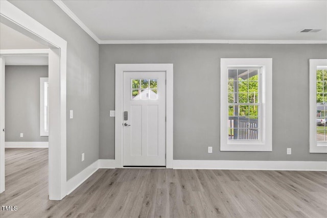 entrance foyer featuring wood finished floors, baseboards, plenty of natural light, and ornamental molding