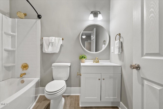 full bathroom featuring wood finished floors, baseboards, toilet, vanity, and bathtub / shower combination