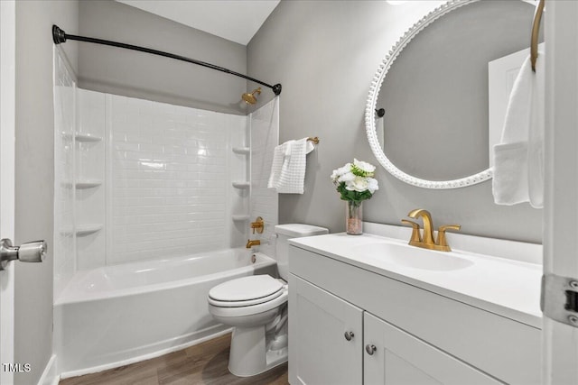 bathroom featuring wood finished floors, toilet, vanity, and bathtub / shower combination
