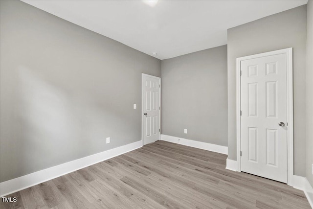 empty room featuring light wood-style flooring and baseboards