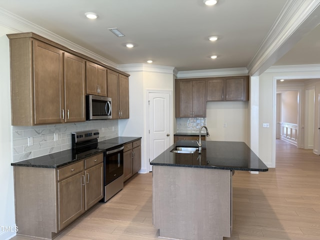 38 Gander Dr, Benson, NC 27504 - kitchen with stainless steel appliances, a sink, crown molding, dark stone counters, and light wood-style floors