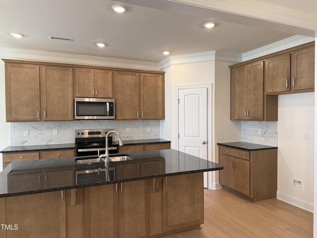 38 Gander Dr, Benson, NC 27504 - kitchen with stainless steel appliances, a sink, baseboards, light wood finished floors, and dark stone countertops