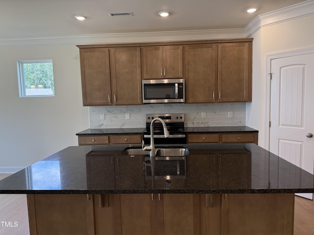38 Gander Dr, Benson, NC 27504 - kitchen with stainless steel appliances, crown molding, a kitchen island with sink, a sink, and decorative backsplash