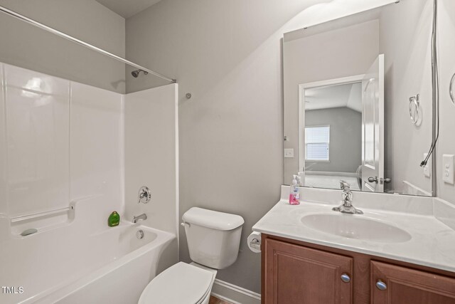 full bath featuring toilet, washtub / shower combination, vanity, and baseboards