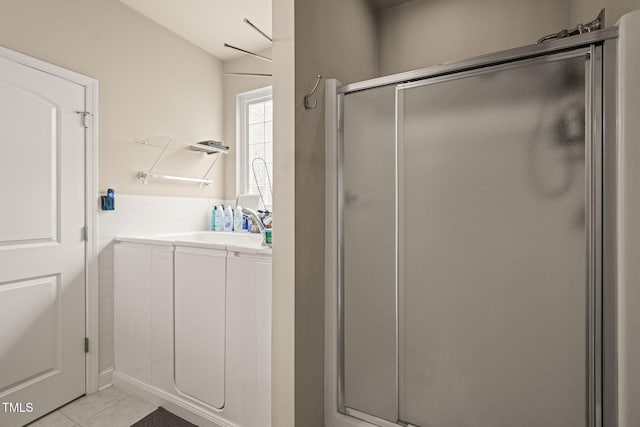 bathroom with a stall shower, tile patterned floors, and vanity