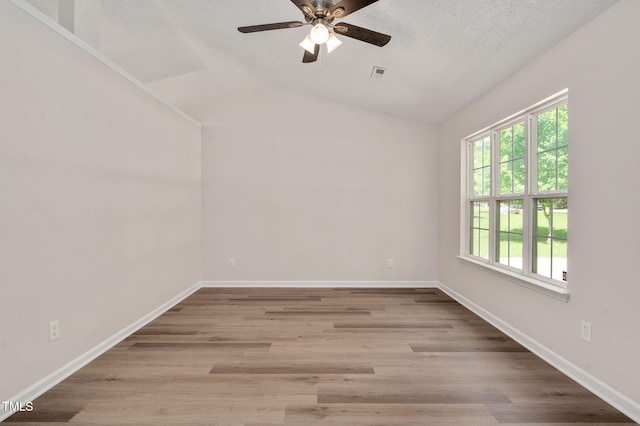empty room featuring a ceiling fan, wood finished floors, lofted ceiling, and baseboards