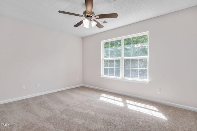 carpeted spare room featuring baseboards, ceiling fan, and a textured ceiling
