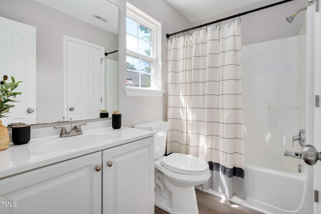 bathroom featuring toilet, vanity, wood finished floors, and shower / bathtub combination with curtain