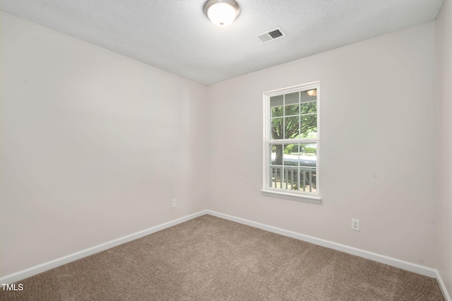 spare room featuring carpet flooring, baseboards, and a textured ceiling