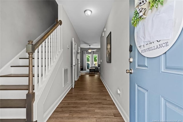 entryway with stairway, dark wood finished floors, ceiling fan, and baseboards