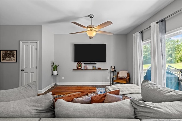 living room with wood finished floors, ceiling fan, and baseboards