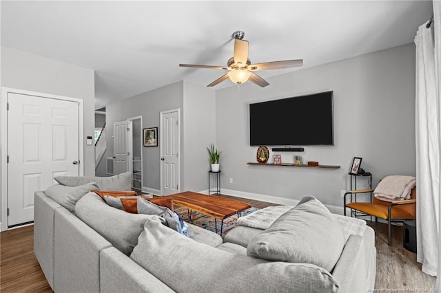 living room with a ceiling fan, wood finished floors, and baseboards