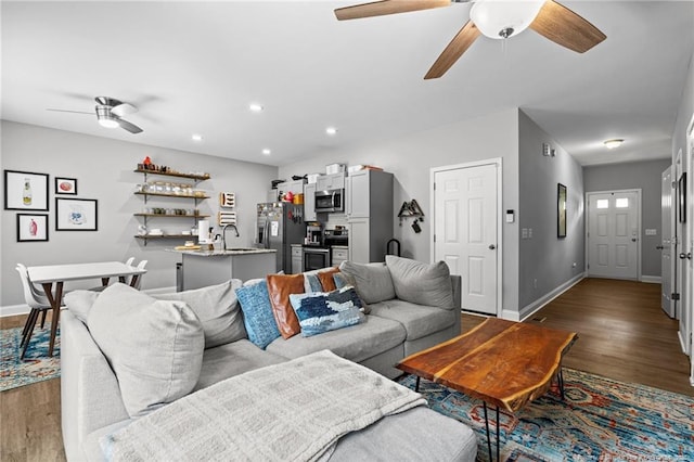 living room featuring ceiling fan, wood finished floors, baseboards, and recessed lighting