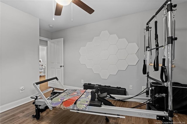 workout area featuring wood finished floors, ceiling fan, and baseboards