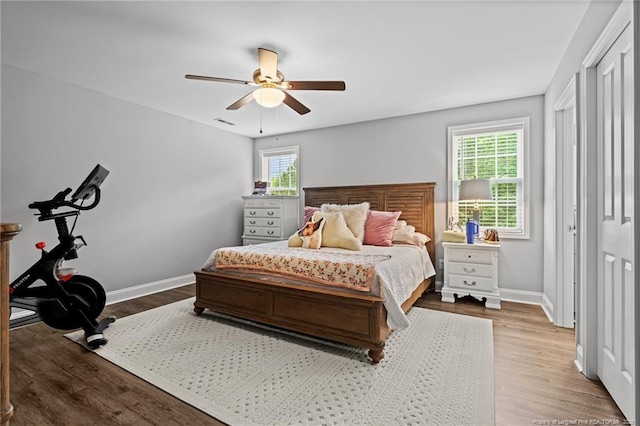 bedroom with wood finished floors, baseboards, and ceiling fan