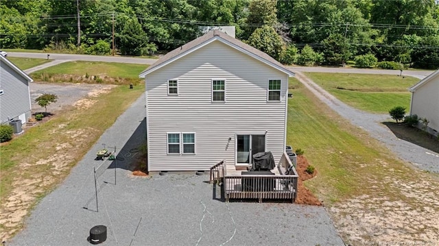 back of house with a wooden deck and a lawn
