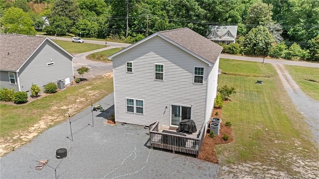 view of side of property with driveway, a deck, a yard, and central air condition unit