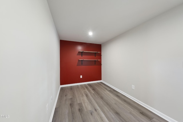 empty room with light wood-style flooring, baseboards, and recessed lighting