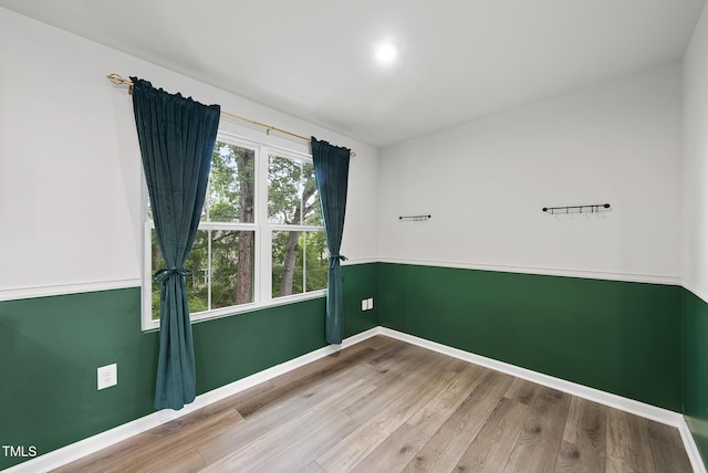 empty room featuring wood finished floors and baseboards
