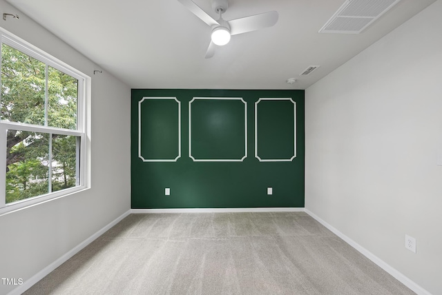 spare room with a ceiling fan, baseboards, and carpet