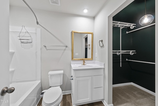 bathroom featuring toilet, vanity, bathtub / shower combination, and baseboards