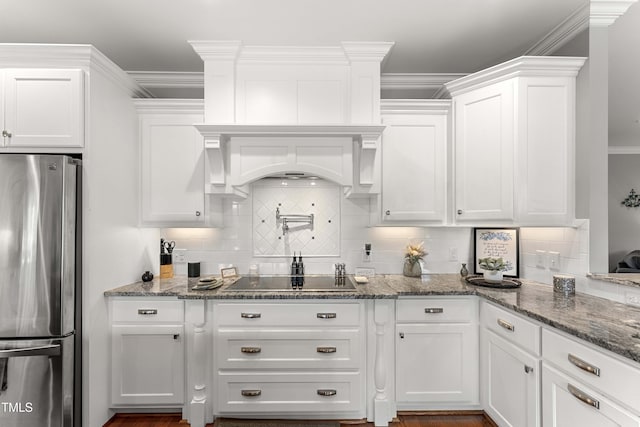 kitchen with freestanding refrigerator, black electric cooktop, white cabinetry, and crown molding