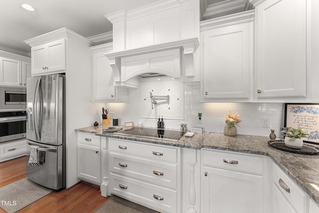 kitchen featuring stainless steel appliances, white cabinetry, decorative backsplash, dark wood-style flooring, and stone counters