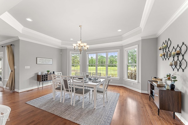 dining room featuring a tray ceiling, a chandelier, hardwood / wood-style flooring, baseboards, and crown molding